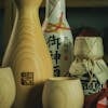 Traditional Japanese sake vessels and bottles on wooden table. Perfect for cultural and culinary themes.
